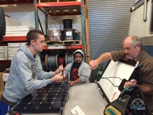 The AM Solar team, strategizing the panel wiring.