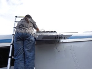 Chris running wires through our conduit and mounting antennas on our new hinged 'hat'. 